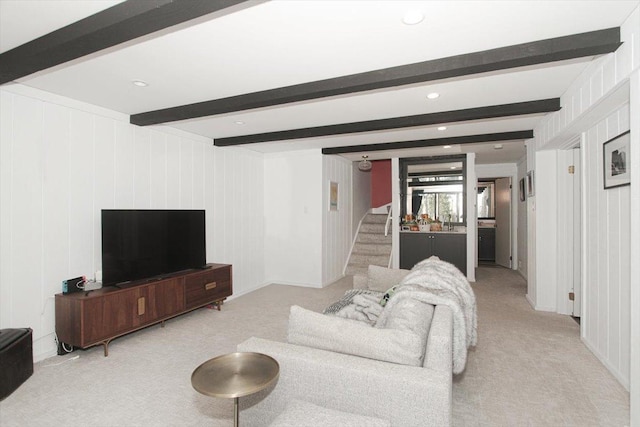 carpeted living room featuring stairs and beamed ceiling