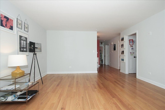 unfurnished living room with light wood-type flooring and baseboards