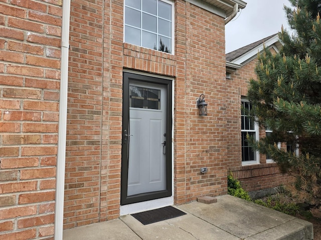 view of exterior entry featuring brick siding