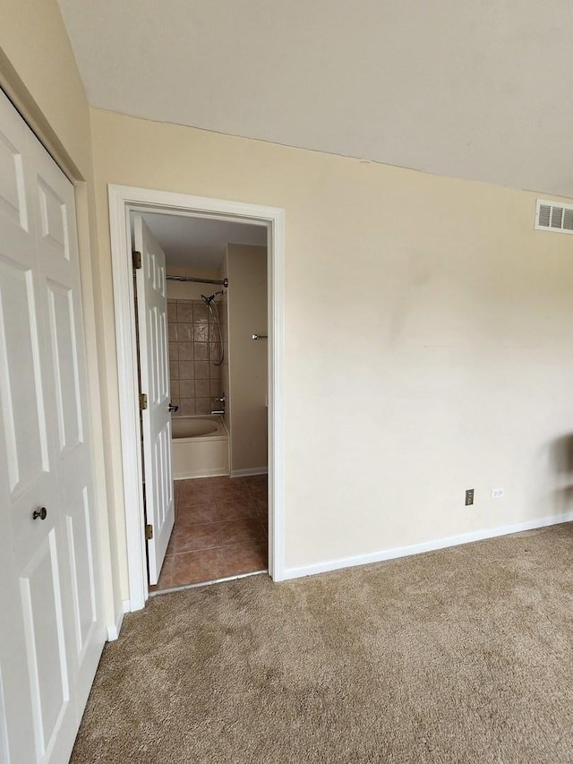 carpeted spare room with tile patterned flooring and baseboards