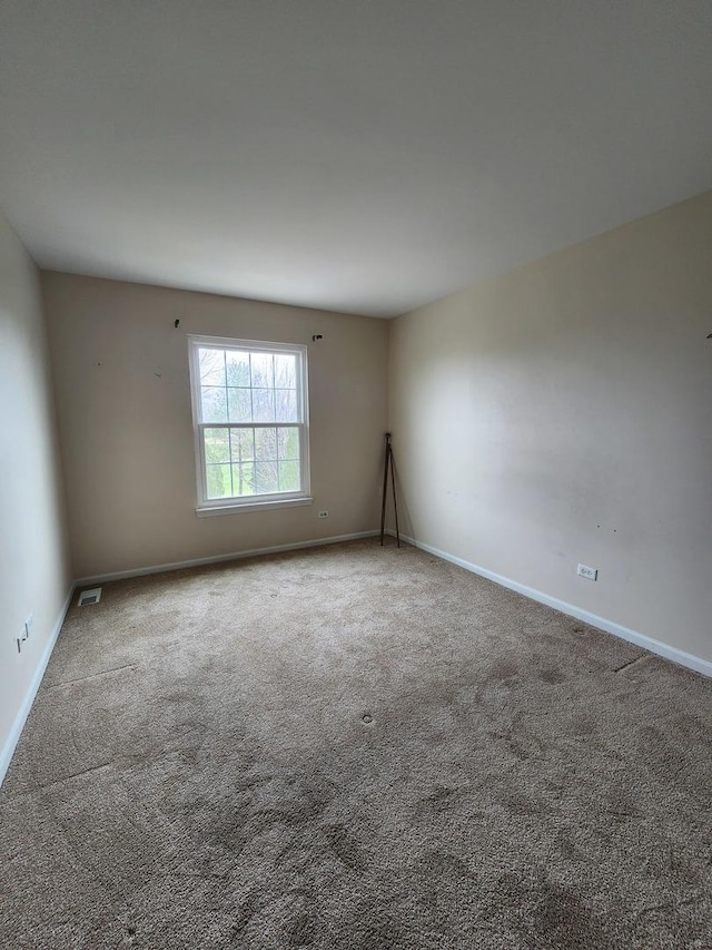 carpeted empty room featuring baseboards