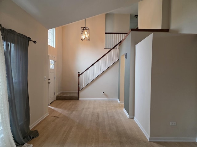 foyer featuring wood finished floors, stairway, and baseboards