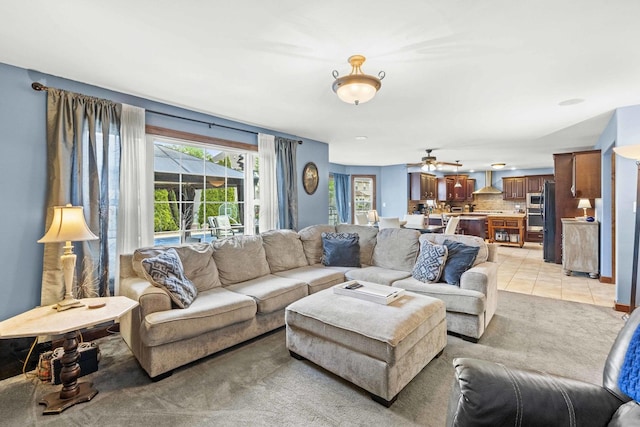 living area with light tile patterned floors and ceiling fan