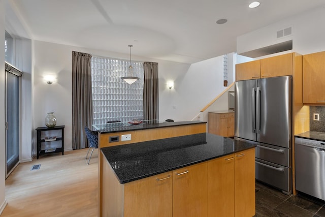 1805 N Paulina St, Chicago, IL 60622 - kitchen featuring appliances with stainless steel finishes, a center island, dark stone countertops, decorative backsplash, and recessed lighting