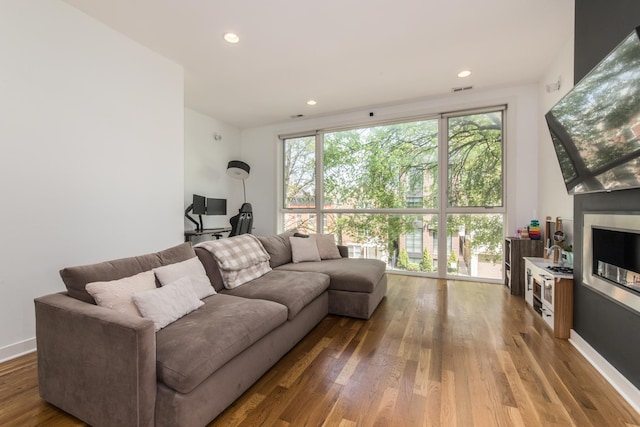 living room featuring wood finished floors, recessed lighting, and baseboards