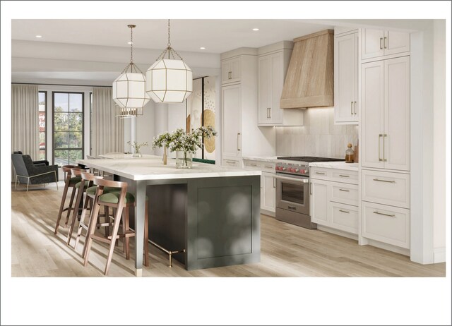 2659 W Medill Ave, Chicago, IL 60647 - kitchen featuring custom exhaust hood, high end stainless steel range oven, an island with sink, light wood-type flooring, and light countertops