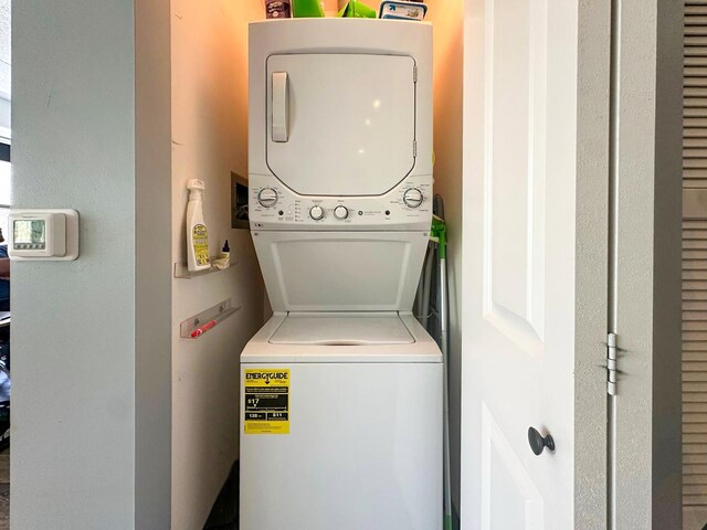 clothes washing area with stacked washer / dryer