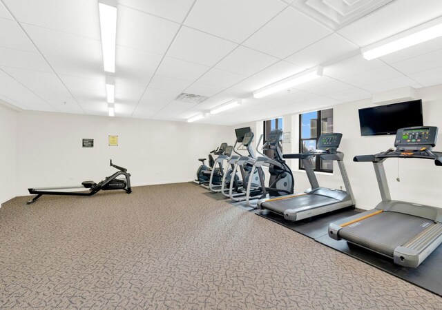 exercise room with baseboards and carpet