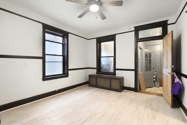 8548 S Manistee Ave, Chicago, IL 60617 - unfurnished bedroom with wood finished floors, baseboards, ceiling fan, and radiator heating unit