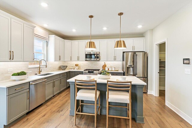 12959 S Boulder Ln, Plainfield, IL 60585 - kitchen featuring appliances with stainless steel finishes, a sink, gray cabinets, decorative backsplash, and a kitchen island