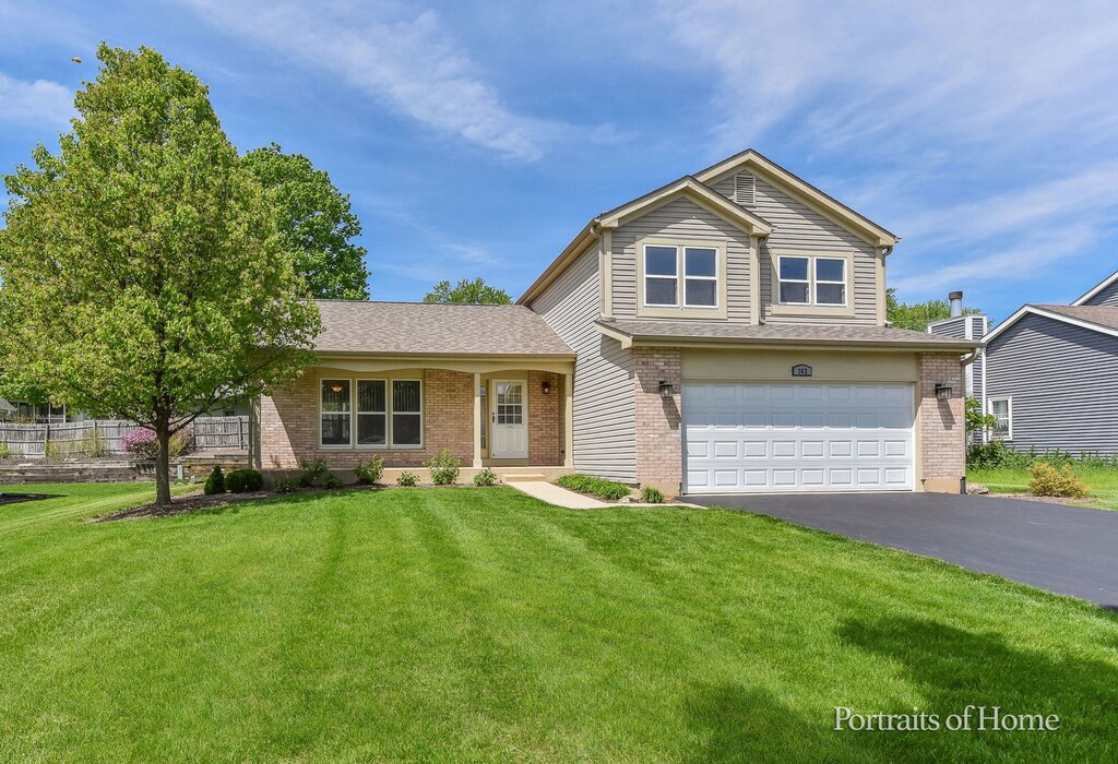 362 Timber Oaks Dr, North Aurora, IL 60542 - traditional-style home featuring asphalt driveway, an attached garage, brick siding, and a front lawn