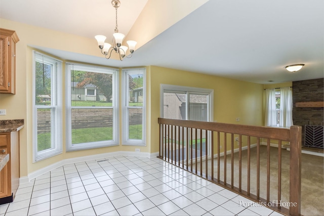 unfurnished dining area featuring a chandelier, light tile patterned floors, lofted ceiling, and baseboards