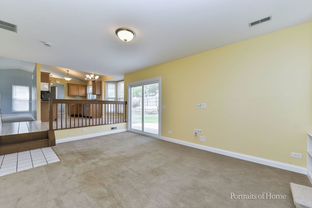 unfurnished living room featuring light carpet, baseboards, and lofted ceiling