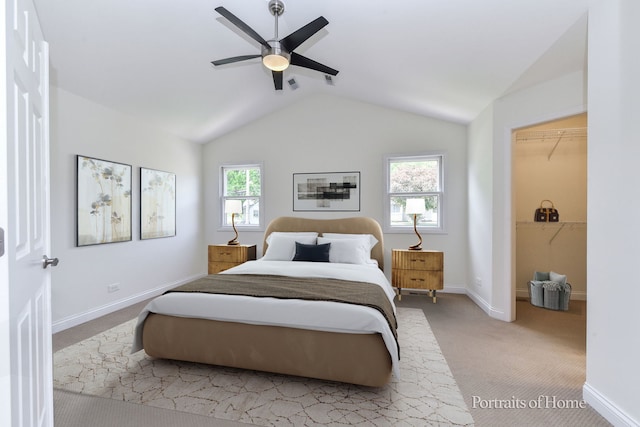 bedroom featuring vaulted ceiling, carpet, baseboards, a spacious closet, and a ceiling fan