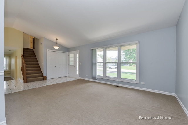 carpeted entrance foyer with vaulted ceiling, healthy amount of natural light, baseboards, and stairway