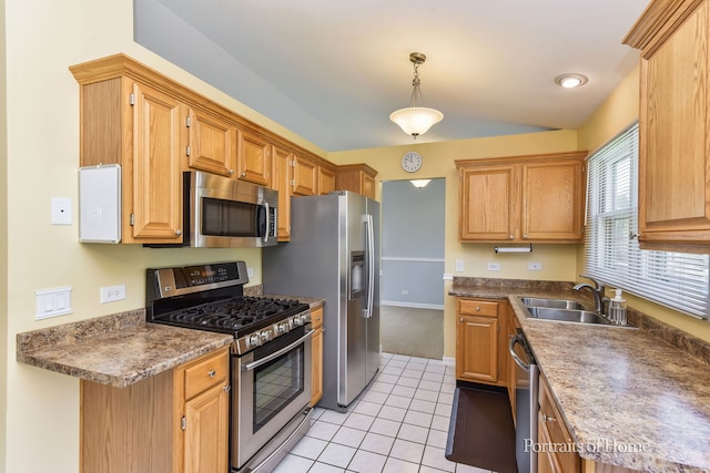 kitchen featuring appliances with stainless steel finishes, a sink, light tile patterned flooring, pendant lighting, and baseboards