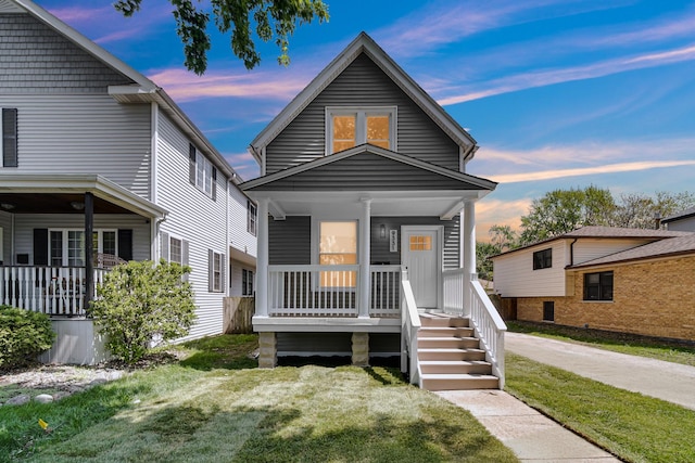 shotgun-style home featuring a porch and a lawn