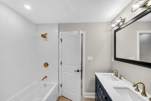 bathroom featuring shower / bath combination, double vanity, baseboards, wood finished floors, and recessed lighting