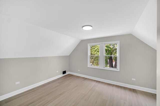 bonus room featuring vaulted ceiling, wood finished floors, and baseboards