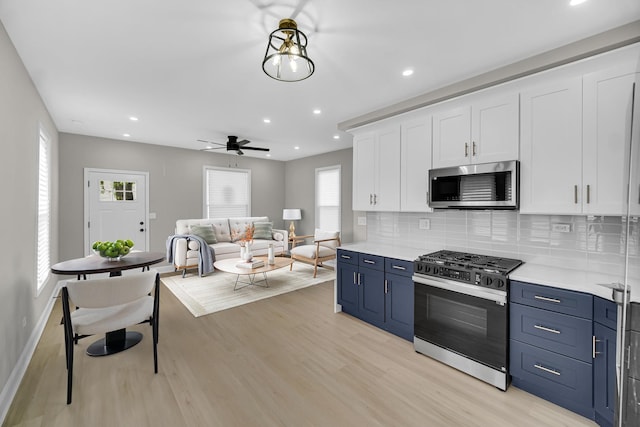 9331 S Turner Ave, Evergreen Park, IL 60805 - kitchen with stainless steel appliances, white cabinets, light wood finished floors, blue cabinetry, and light countertops