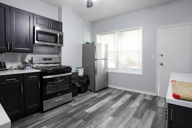 1002 N Drake Ave, Chicago, IL 60651 - kitchen with appliances with stainless steel finishes, dark cabinetry, dark wood finished floors, light countertops, and ceiling fan