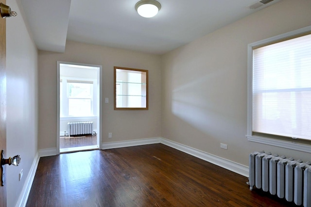 5813 W Eastwood Ave, Chicago, IL 60630 - spare room with radiator, dark wood-style flooring, and baseboards