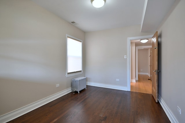 5813 W Eastwood Ave, Chicago, IL 60630 - spare room with radiator heating unit, dark wood-type flooring, and baseboards