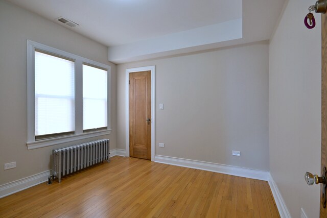 5813 W Eastwood Ave, Chicago, IL 60630 - spare room featuring radiator, light wood-style floors, and baseboards