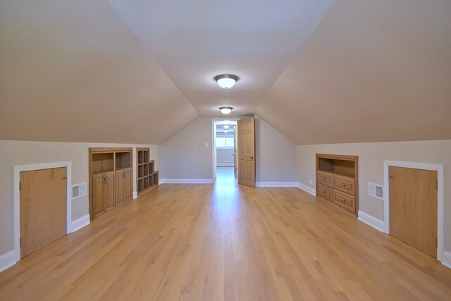 5813 W Eastwood Ave, Chicago, IL 60630 - additional living space with built in features, light wood-style flooring, baseboards, and lofted ceiling