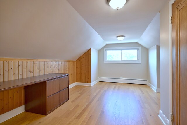 5813 W Eastwood Ave, Chicago, IL 60630 - additional living space featuring a baseboard heating unit, light wood-style floors, lofted ceiling, wood walls, and baseboards