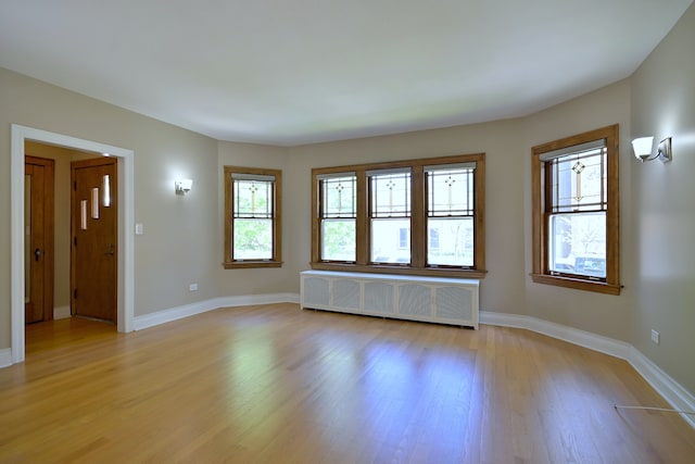 5813 W Eastwood Ave, Chicago, IL 60630 - spare room featuring radiator heating unit, light wood-style floors, and baseboards