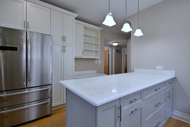 5813 W Eastwood Ave, Chicago, IL 60630 - kitchen featuring stainless steel fridge, open shelves, light wood-style floors, and pendant lighting