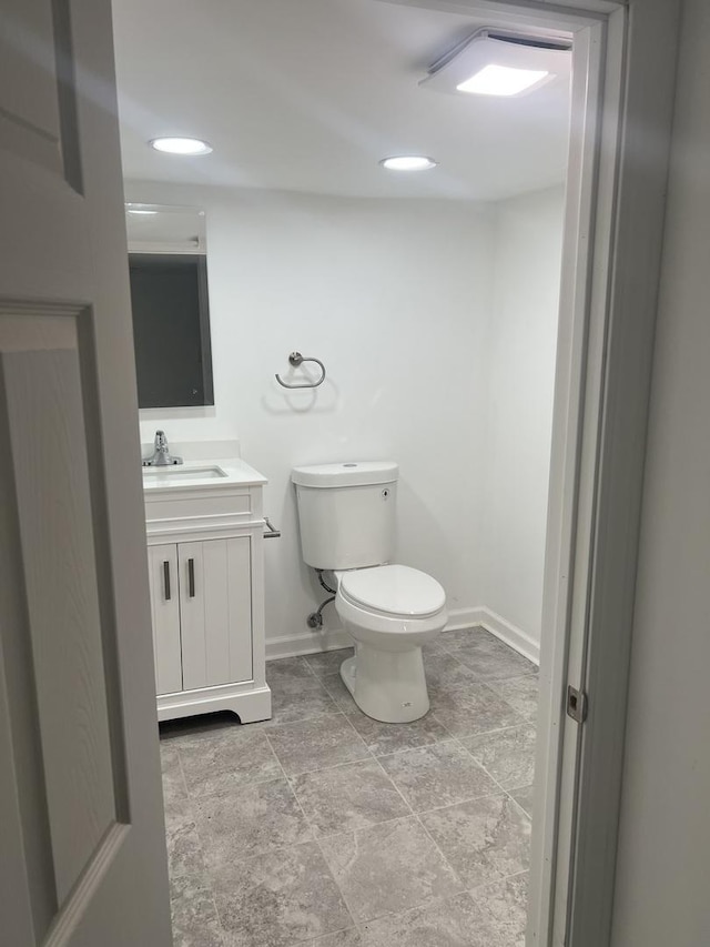 10642 S Calhoun Ave, Chicago, IL 60617 - bathroom with baseboards, toilet, vanity, stone finish flooring, and recessed lighting