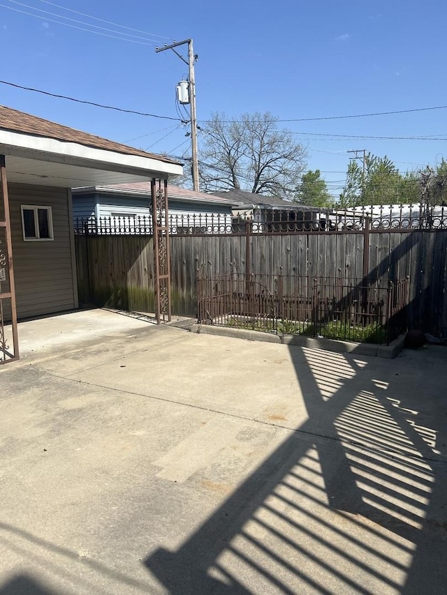 10642 S Calhoun Ave, Chicago, IL 60617 - view of patio with fence, an attached carport, and driveway