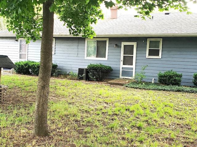 517 S Hebbard St, Joliet, IL 60433 - back of house with a chimney, a yard, and roof with shingles