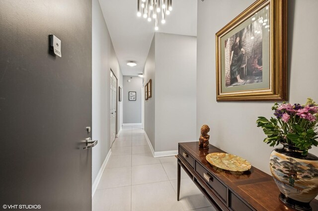 1160 S Michigan Ave Unit 3805, Chicago, IL 60605 - corridor featuring light tile patterned floors, baseboards, and a chandelier