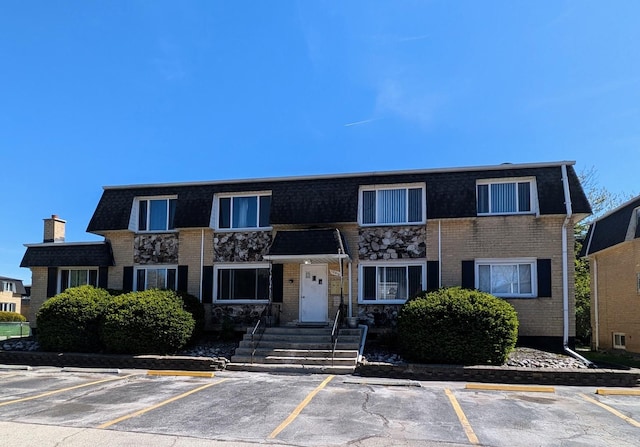 view of front of property featuring uncovered parking and brick siding
