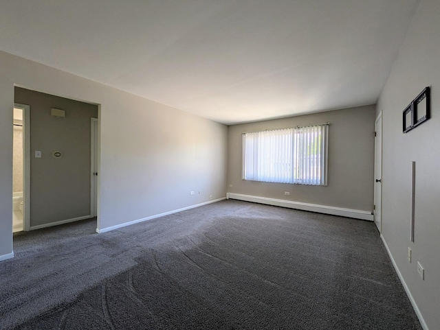 spare room featuring a baseboard radiator, dark carpet, and baseboards