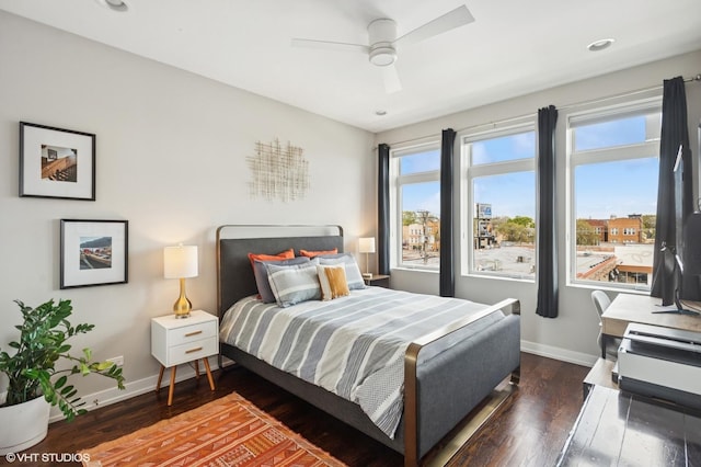 bedroom with baseboards, dark wood-type flooring, and ceiling fan