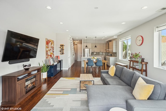 living area with dark wood-style flooring, recessed lighting, and baseboards