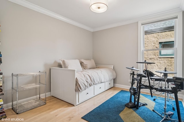 bedroom with ornamental molding, wood finished floors, and baseboards