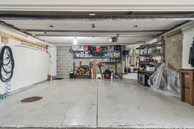 garage with a garage door opener and concrete block wall