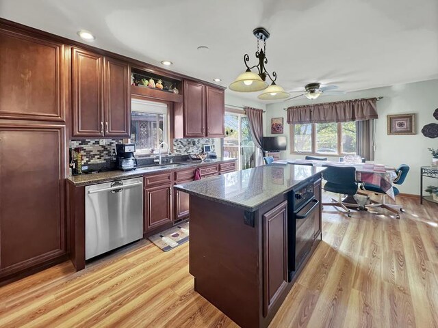 2919 193rd St, Lansing, IL 60438 - kitchen featuring stainless steel dishwasher, oven, light wood-type flooring, a sink, and decorative light fixtures