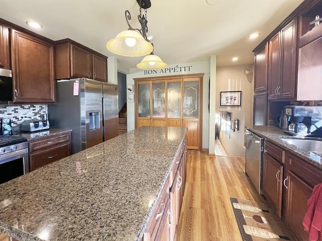 2919 193rd St, Lansing, IL 60438 - kitchen featuring stainless steel appliances, tasteful backsplash, dark stone counters, light wood-style floors, and recessed lighting
