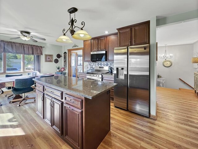 2919 193rd St, Lansing, IL 60438 - kitchen featuring stainless steel appliances, a ceiling fan, light wood-style flooring, dark stone countertops, and decorative backsplash