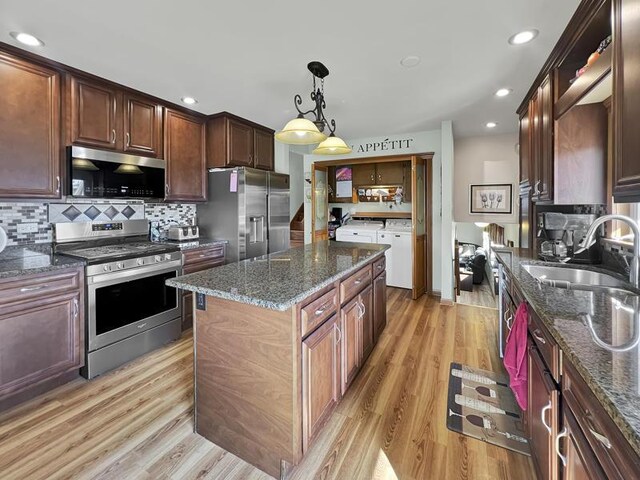 2919 193rd St, Lansing, IL 60438 - kitchen with stainless steel appliances, independent washer and dryer, a sink, a kitchen island, and tasteful backsplash
