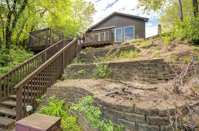 rear view of property featuring a deck and stairs