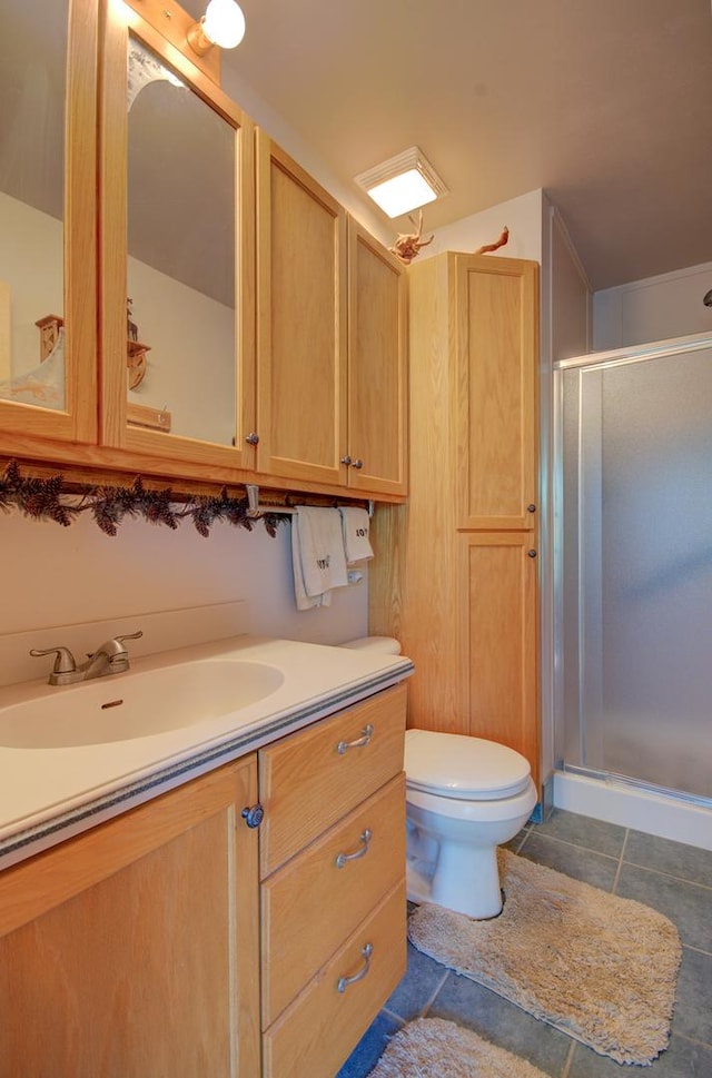 bathroom with a shower stall, vanity, toilet, and tile patterned flooring
