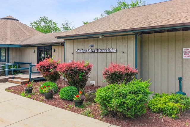 entrance to property featuring a shingled roof