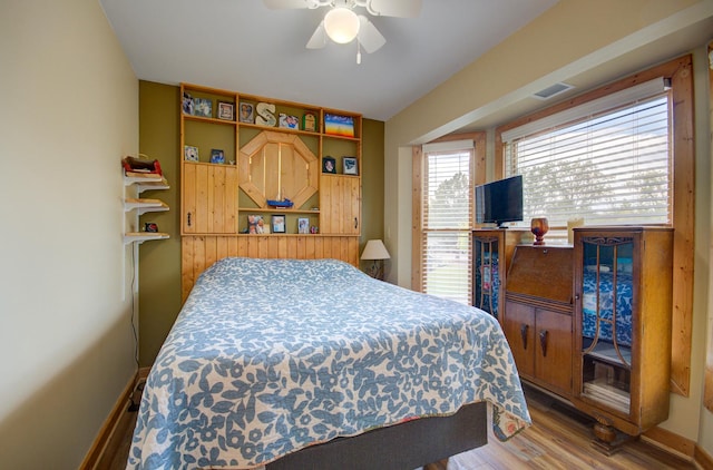 bedroom featuring wood finished floors, ceiling fan, and baseboards
